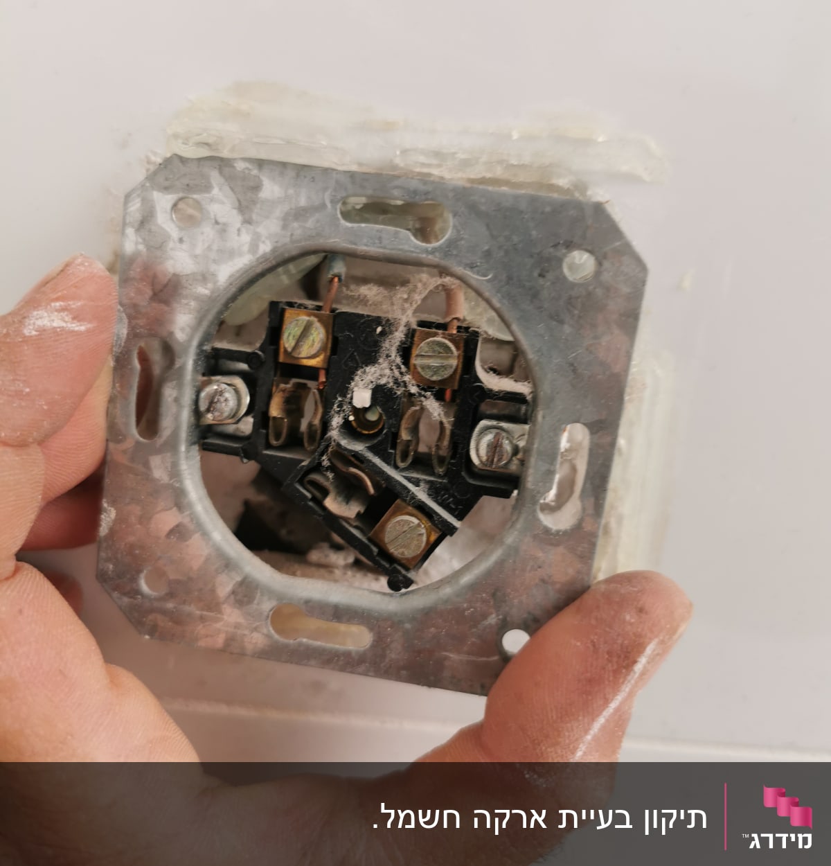 יד מחזיקה שקע חשמלי עם חוטים חשופים
